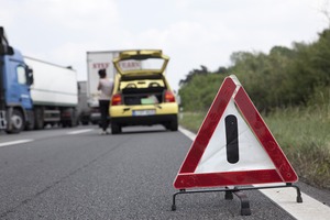 junge Frau mit Autopanne auf Autobahn